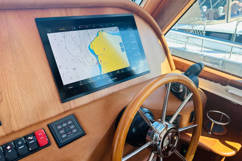 Slide: The Image of Helm of 2025 Sabre 48 Salon Express with navigation display and wooden steering wheel. - 28