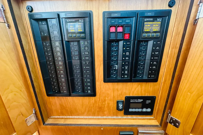 Slide: The Image of Electrical control panel on 2025 Sabre 48 Salon Express yacht, featuring circuit breakers and displays. - 35