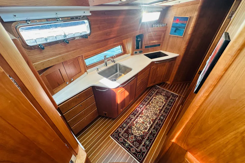 Slide: The Image of Luxurious 2025 Sabre 48 Salon Express yacht interior with elegant wooden cabinetry and modern kitchen. - 36