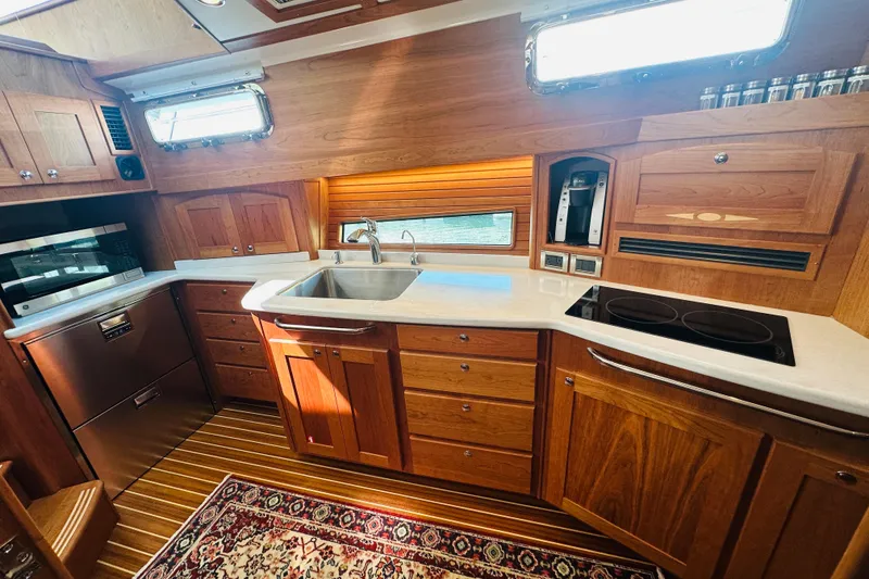 Slide: The Image of Luxurious 2025 Sabre 48 Salon Express yacht kitchen with wood cabinetry and modern appliances. - 37