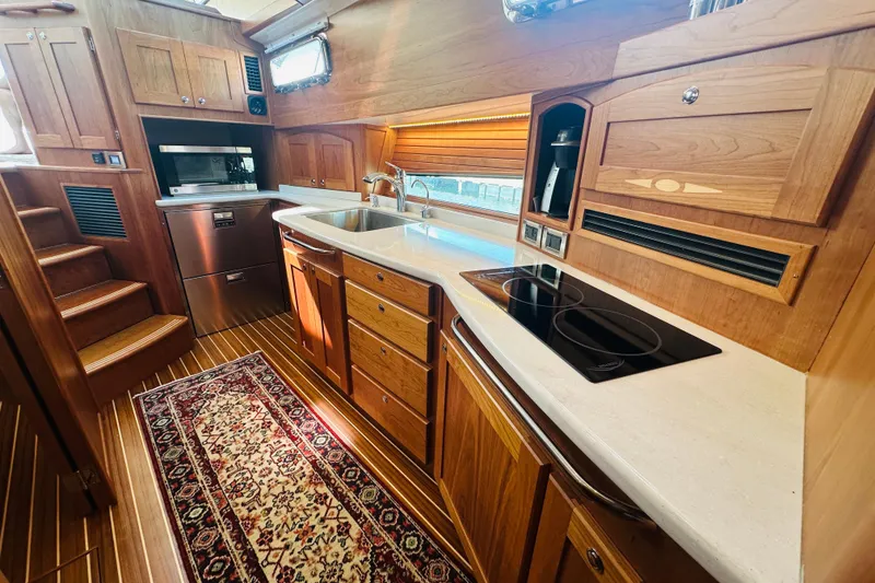 Slide: The Image of Luxurious 2025 Sabre 48 Salon Express yacht kitchen with wood cabinetry and modern appliances. - 38