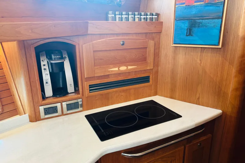 Slide: The Image of The 2025 Sabre 48 Salon Express kitchen features a cooktop and a coffee maker. - 41
