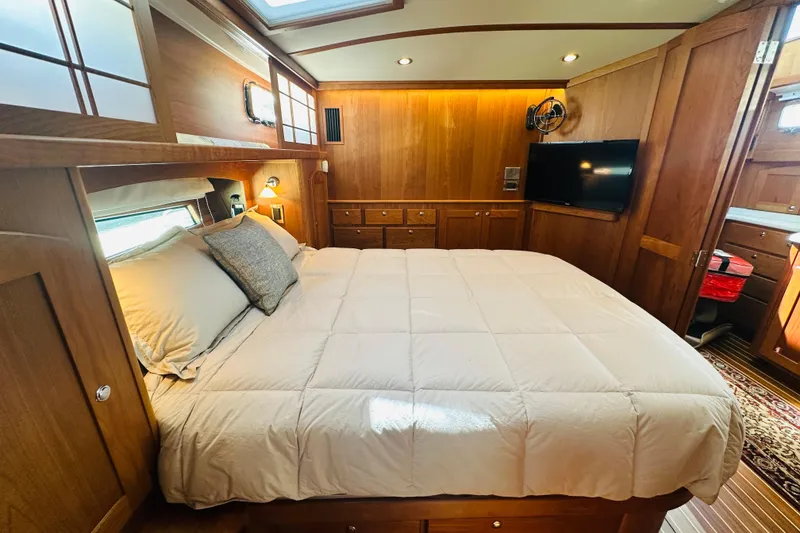 Slide: The Image of Luxurious bedroom interior of 2025 Sabre 48 Salon Express yacht with wood paneling and cozy bedding. - 46