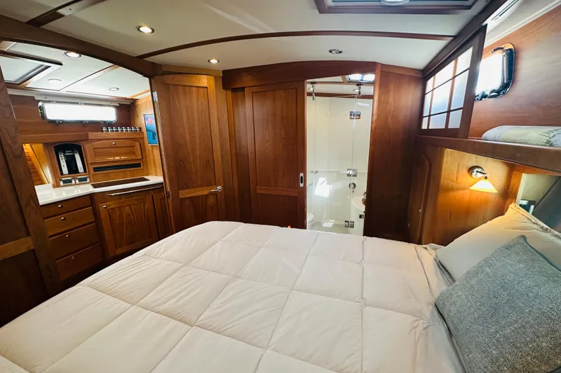 Slide: The Image of Luxurious interior of 2025 Sabre 48 Salon Express yacht with wood finish and cozy bedding. - 48