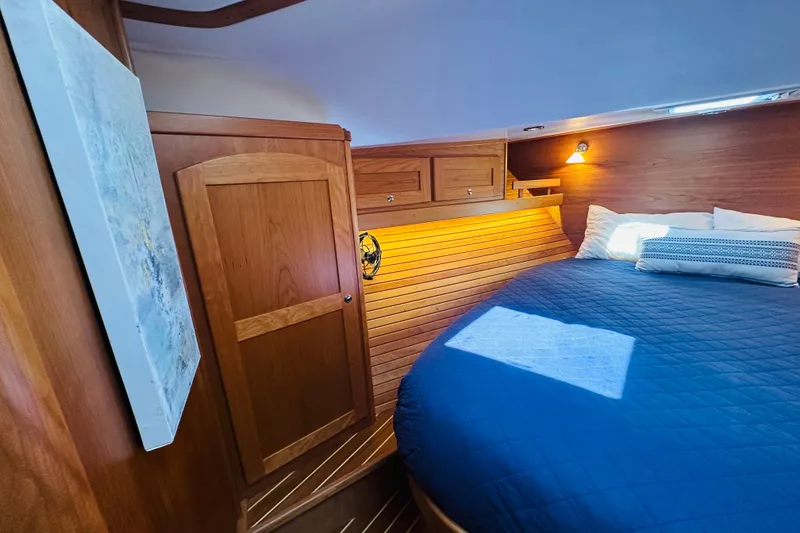 Slide: The Image of Luxurious cabin interior of 2025 Sabre 48 Salon Express with wooden finishes and cozy bedding. - 54