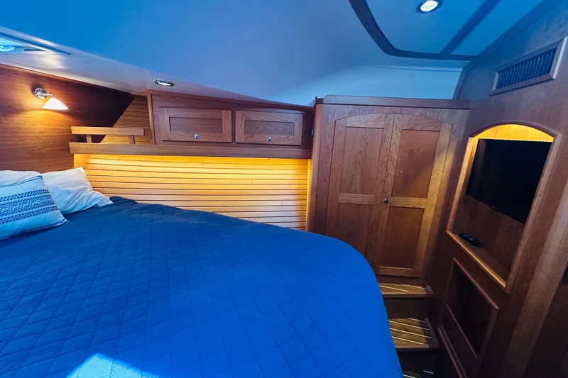 Slide: The Image of Luxurious cabin interior of 2025 Sabre 48 Salon Express with wood paneling and cozy bedding. - 55