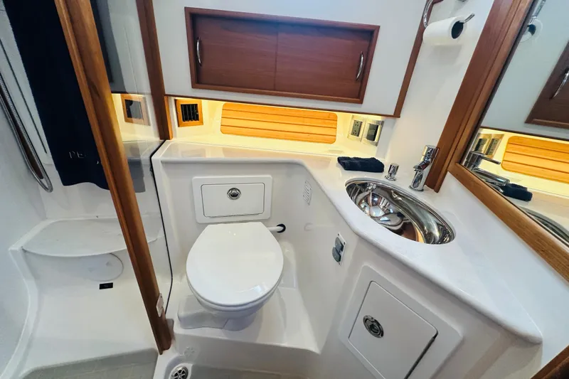 Slide: The Image of 2025 Sabre 48 Salon Express bathroom with modern fixtures and wooden accents. - 58