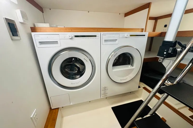 Slide: The Image of Laundry area inside 2025 Sabre 48 Salon Express yacht, featuring modern washer and dryer. - 60