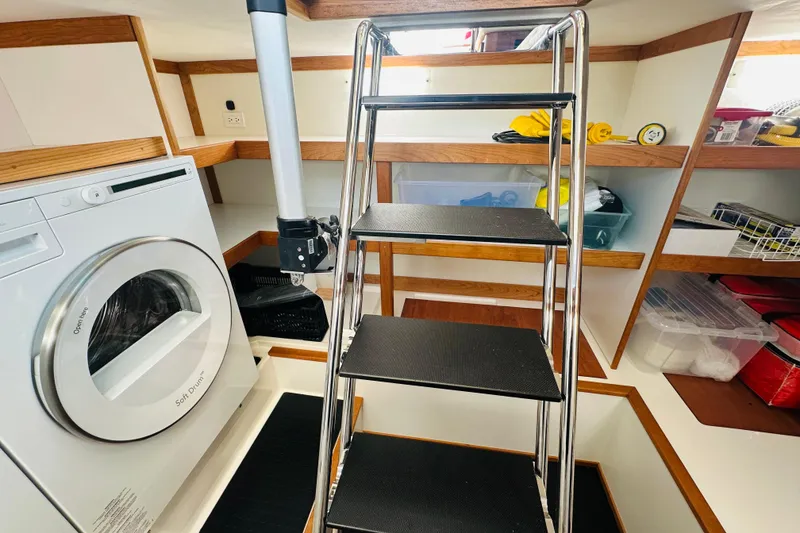 Slide: The Image of Laundry area with washer and storage shelves in 2025 Sabre 48 Salon Express yacht. - 62