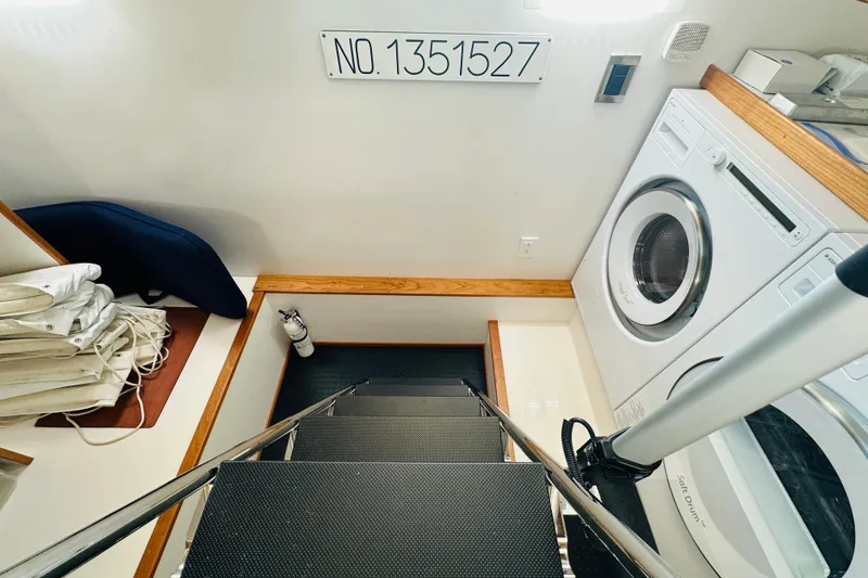 Slide: The Image of Laundry area on 2025 Sabre 48 Salon Express yacht with washer, dryer, and storage. - 64