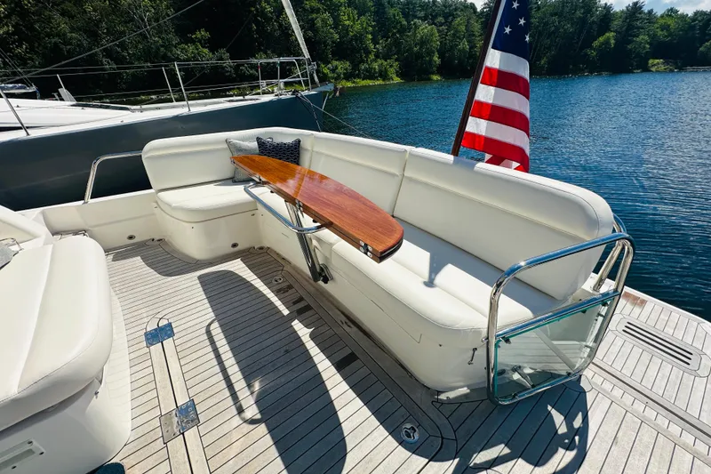Slide: The Image of Luxurious 2025 Sabre 48 Salon Express yacht deck with seating and American flag. - 65