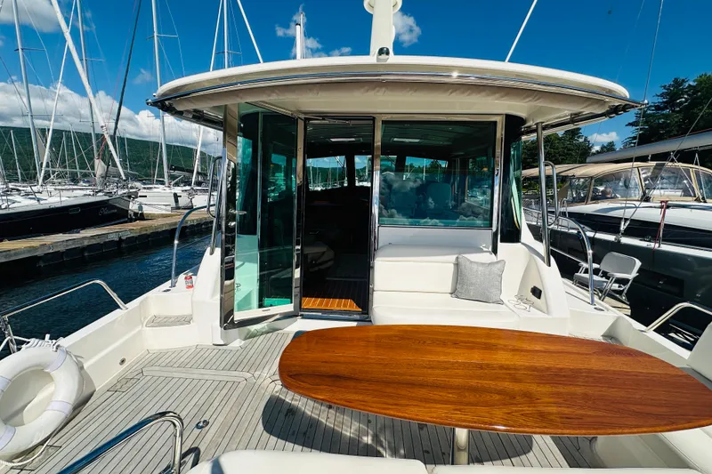 Slide: The Image of 2025 Sabre 48 Salon Express yacht with elegant deck and seating area at marina. - 7