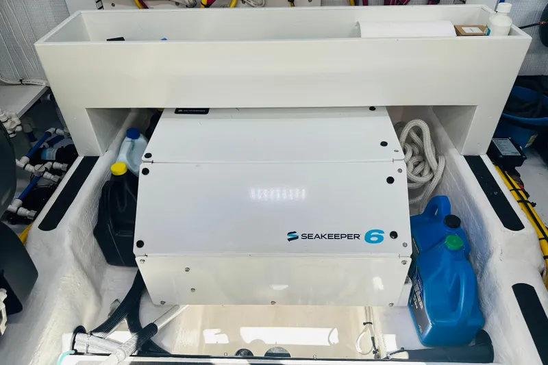 Slide: The Image of Seakeeper 6 stabilizer in 2025 Sabre 48 Salon Express engine room, surrounded by maintenance supplies. - 81