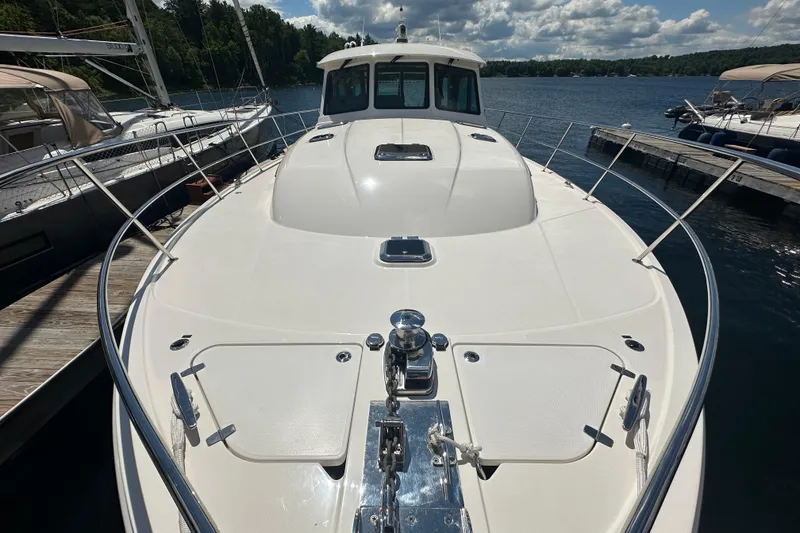 Slide: The Image of 2025 Sabre 48 Salon Express yacht docked on a sunny day, showcasing sleek design. - 86
