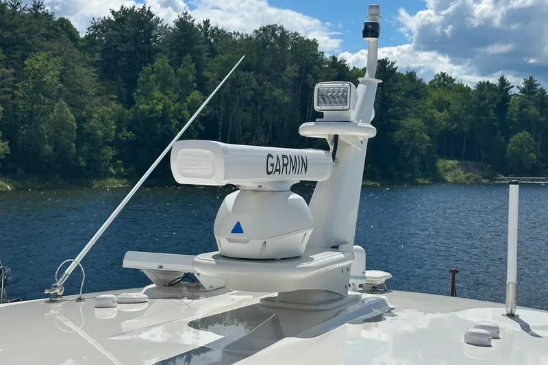 Slide: The Image of 2025 Sabre 48 Salon Express with Garmin radar on a serene lake backdrop. - 91