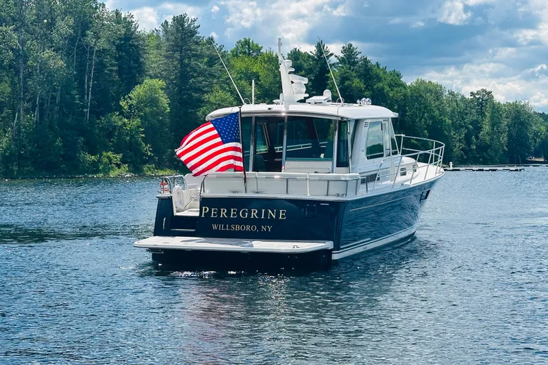 Slide: The Image of 2025 Sabre 48 Salon Express boat on a lake with American flag. - 92