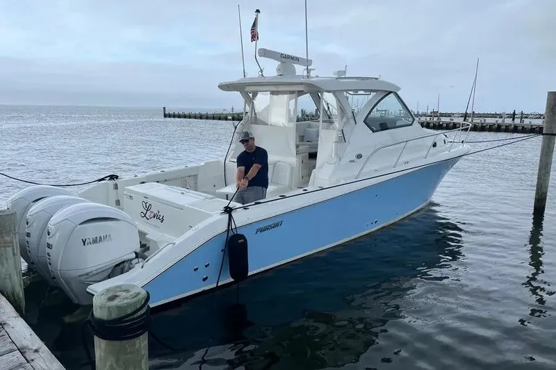 The Image of 2023 Pursuit OS 355 Offshore boat docked with Yamaha engines, featuring a sleek design. - 1