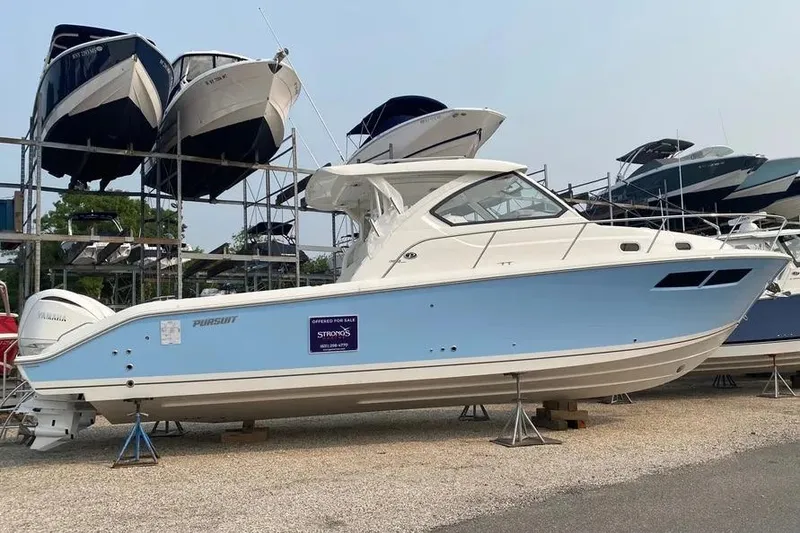 Slide: The Image of 2023 Pursuit OS 355 Offshore boat displayed on stands, surrounded by other boats. - 3