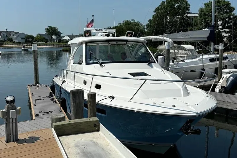 Slide: The Image of 2023 Pursuit OS 355 Offshore boat docked at marina, sunny day. - 4