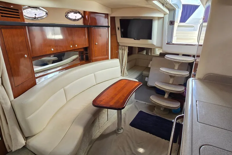 Slide: The Image of 2007 Sea Ray 340 Sundancer interior with elegant seating, wooden table, and modern amenities. - 17
