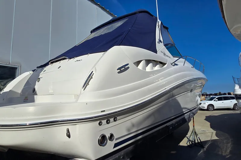 Slide: The Image of 2007 Sea Ray 340 Sundancer boat with blue cover, docked outdoors. - 4