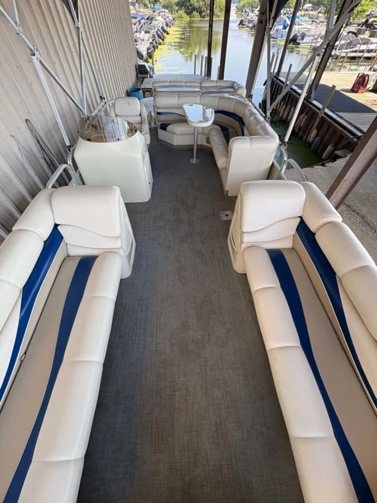 Slide: The Image of The image shows the interior of a Bennington 2250 LX pontoon boat with white and blue seating. - 2