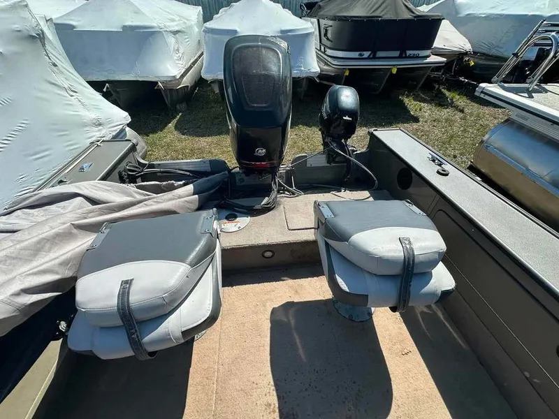 Slide: The Image of The image shows the stern of a 2004 Lund 18 MR PIKE boat with two seats and an outboard motor. - 11