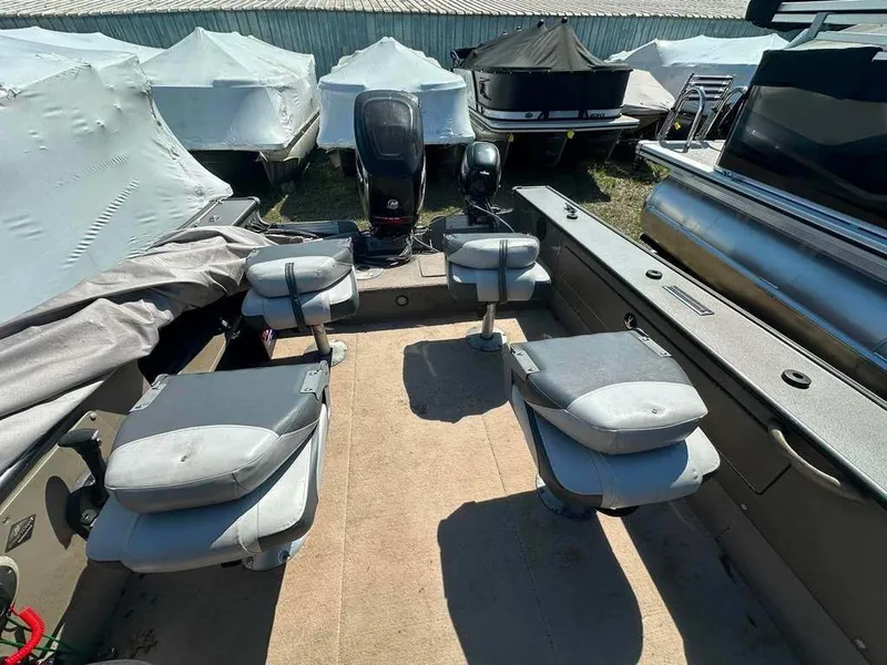 Slide: The Image of The image shows a 2004 Lund 18 MR PIKE boat with four swivel seats and an outboard motor. - 10