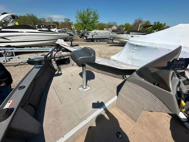 Slide: The Image of A 2004 Lund 18 MR PIKE boat in a parking area with other boats. - 3