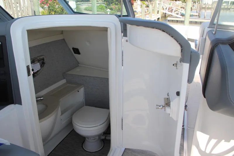 Slide: The Image of 2021 Cobalt 25SC boat interior with compact bathroom and toilet. - 13