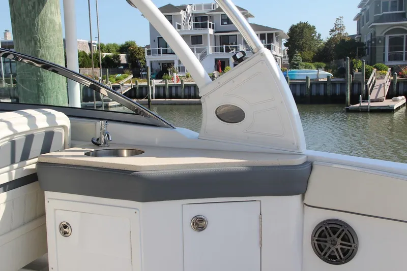 Slide: The Image of 2021 Cobalt 25SC boat interior with sink, docked near waterfront homes. - 8