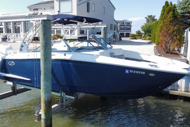 Slide: The Image of 2021 Cobalt 25SC boat docked near waterfront homes. - 2