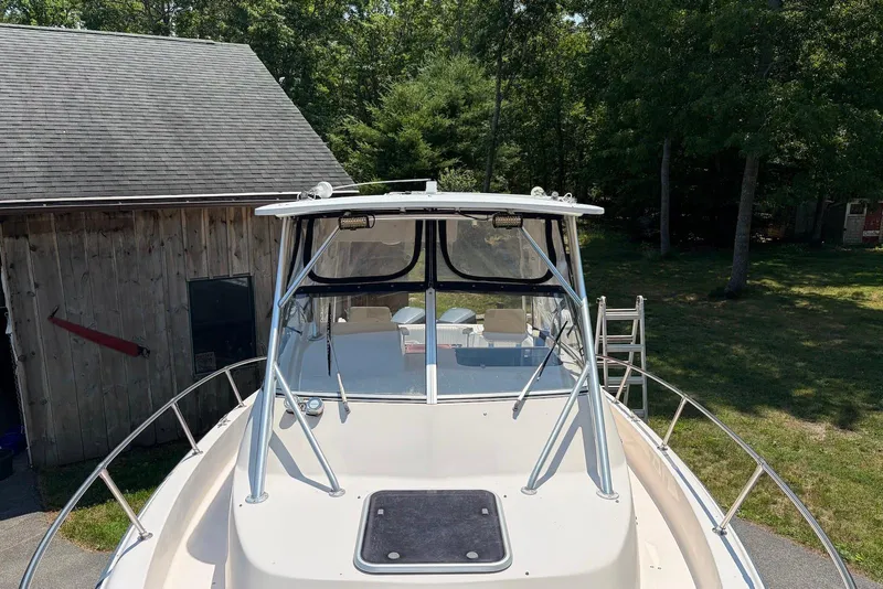 Slide: The Image of 1999 Grady-White Marlin 300 boat docked near a wooden shed, surrounded by trees. - 5
