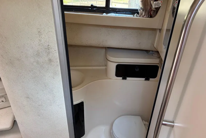 Slide: The Image of 1999 Grady-White Marlin 300 boat bathroom interior with toilet and storage compartments. - 13