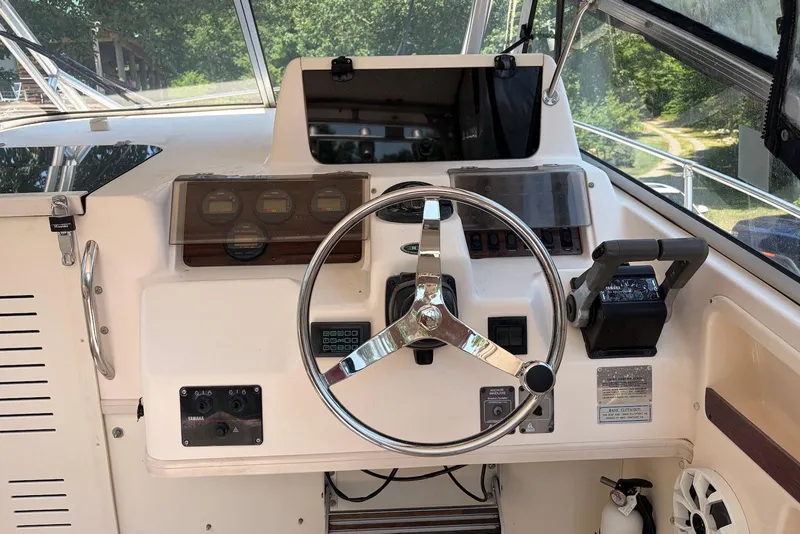 Slide: The Image of 1999 Grady-White Marlin 300 boat helm with steering wheel and control panel. - 6