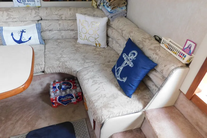 Slide: The Image of Interior of 1990 Sea Ray 350 Express Cruiser with nautical-themed cushions and seating area. - 28