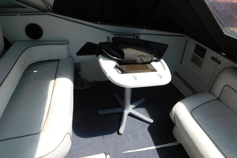 Slide: The Image of Interior of a 1990 Sea Ray 350 Express Cruiser with white seating and a small table. - 8