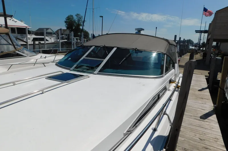 Slide: The Image of 1990 Sea Ray 350 Express Cruiser docked at a marina under a clear blue sky. - 5