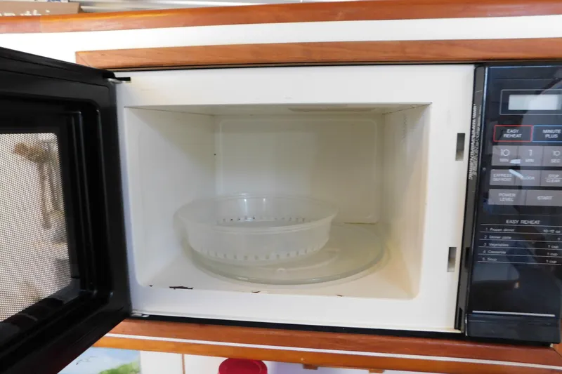 Slide: The Image of Open microwave oven inside a 1990 Sea Ray 350 Express Cruiser kitchen. - 54