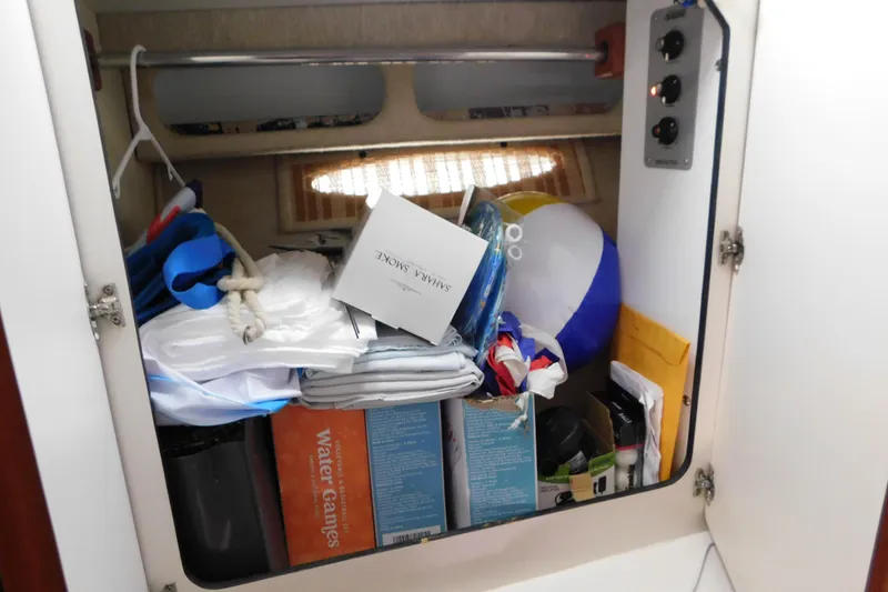 Slide: The Image of Storage compartment in a 1990 Sea Ray 350 Express Cruiser, filled with various boating items. - 34