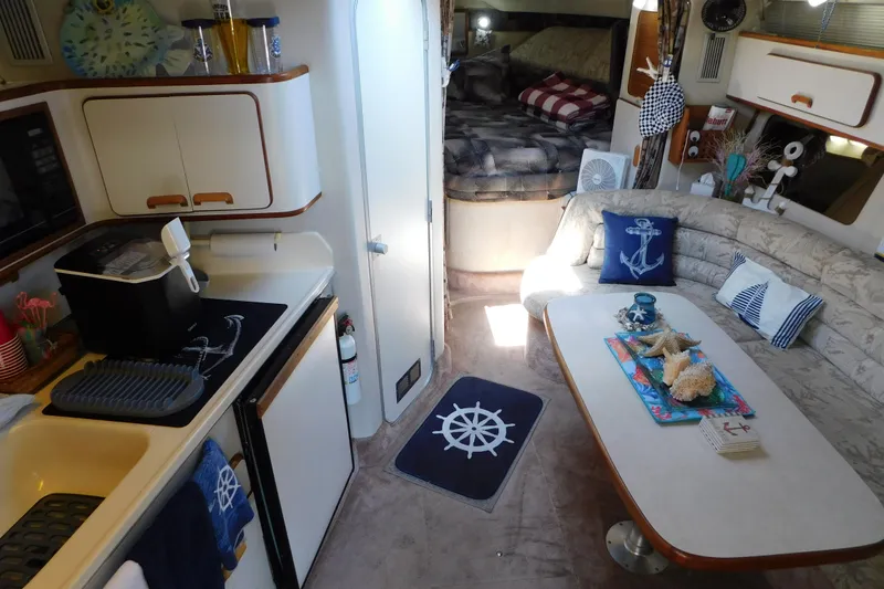 Slide: The Image of Interior of 1990 Sea Ray 350 Express Cruiser with nautical decor and cozy seating area. - 26
