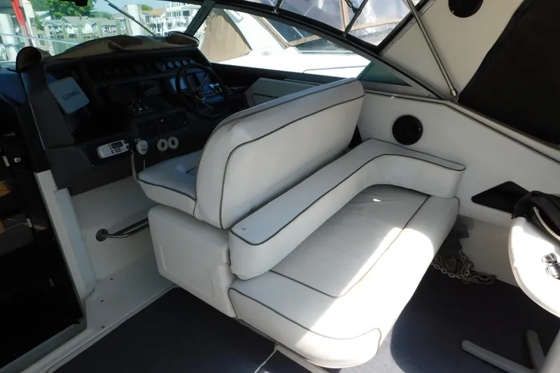 Slide: The Image of Interior of 1990 Sea Ray 350 Express Cruiser with white seating and helm controls. - 9