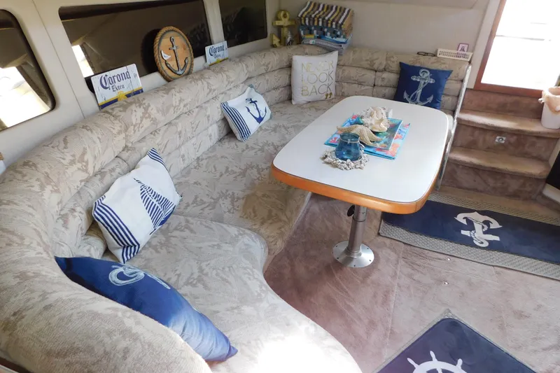 Slide: The Image of Interior of 1990 Sea Ray 350 Express Cruiser with nautical-themed decor and cozy seating area. - 47