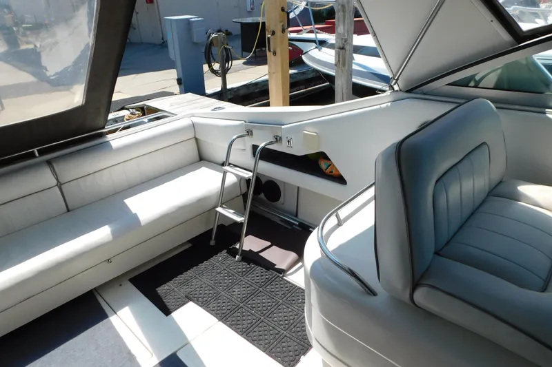 Slide: The Image of Interior of 1990 Sea Ray 350 Express Cruiser with white seating and ladder. - 20