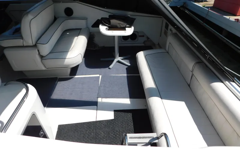 Slide: The Image of Interior of a 1990 Sea Ray 350 Express Cruiser with white seating and table. - 6