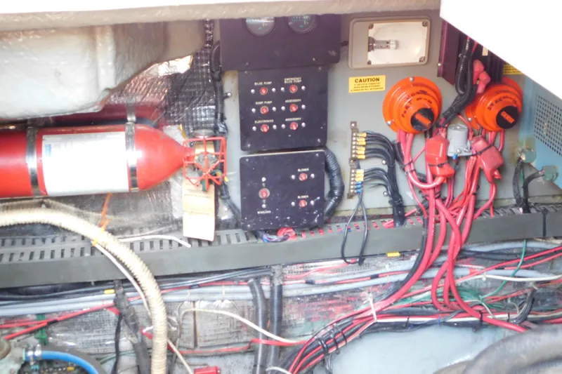 Slide: The Image of Engine compartment of a 1990 Sea Ray 350 Express Cruiser with wiring and fire extinguisher. - 68