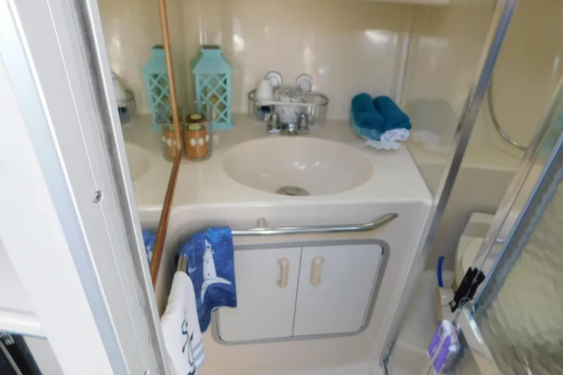 Slide: The Image of Bathroom interior of 1990 Sea Ray 350 Express Cruiser with sink and nautical decor. - 44