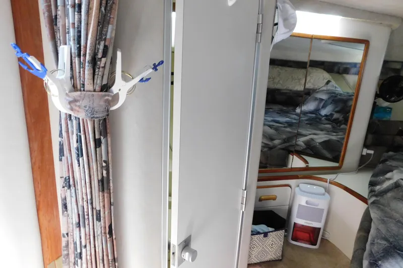 Slide: The Image of Interior of 1990 Sea Ray 350 Express Cruiser with curtains, mirror, and dehumidifier. - 37