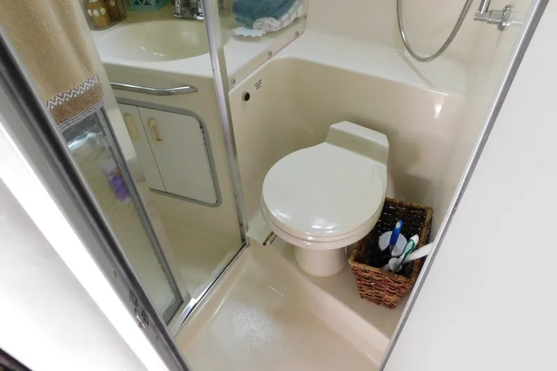 Slide: The Image of Bathroom interior of 1990 Sea Ray 350 Express Cruiser with toilet and shower. - 38