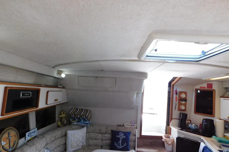Slide: The Image of Interior of a 1990 Sea Ray 350 Express Cruiser, featuring cozy seating and nautical decor. - 48